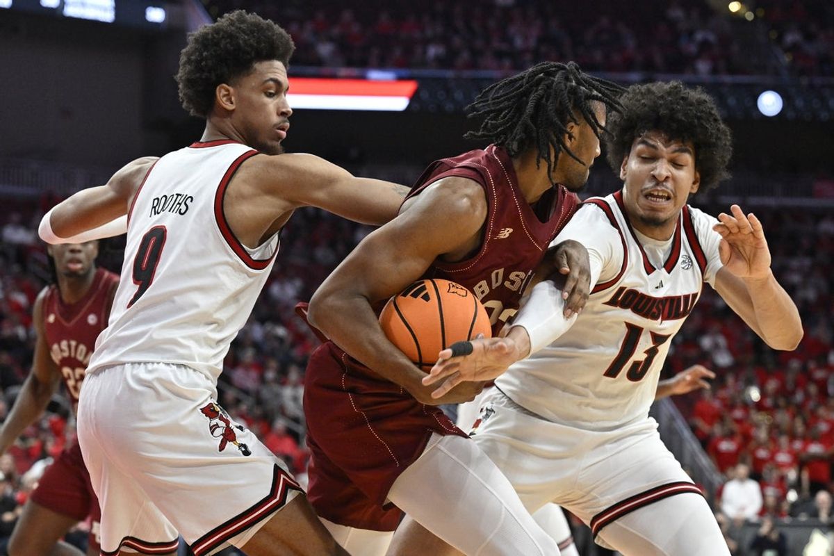 Jan 10, 2026; Louisville, Kentucky, USA;  Louisville Cardinals forward Sananda Fru (13) and forward Khani Rooths (9) double team Boston College Eagles guard Aidan Shaw (23) during the first half at KFC Yum! Center. Mandatory Credit: Jamie Rhodes-Imagn Images