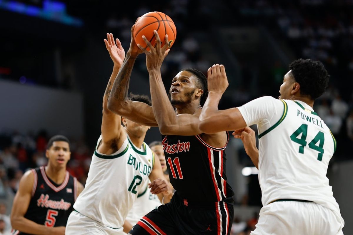 Jan 10, 2026; Waco, Texas, USA; Houston Cougars forward Joseph Tugler (11) drives to the basket between Baylor Bears guard Michael Rataj (12) and center Caden Powell (44) during the first half at Paul and Alejandra Foster Pavilion. Mandatory Credit: Chris Jones-Imagn Images