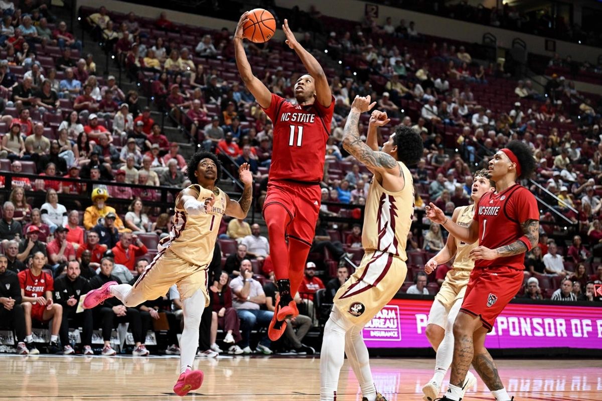 Jan 10, 2026; Tallahassee, Florida, USA; North Carolina State Wolfpack guard Quadir Copeland (11) shoots the ball past Florida State Seminoles guard Martin Somerville (1) during the second half at Donald L. Tucker Center. Mandatory Credit: Melina Myers-Imagn Images