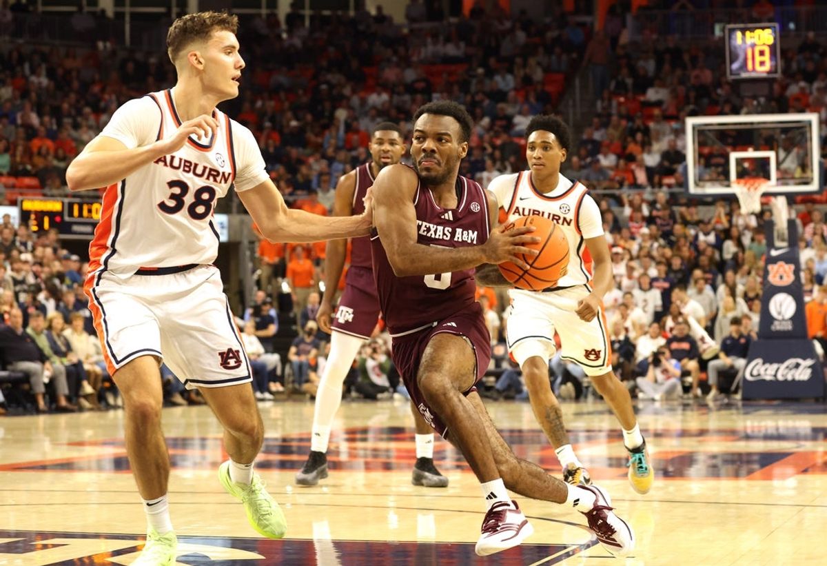 Dec 3, 2025; Auburn, Alabama, USA;  Texas A&M Aggies guard Jacari Lane (5) drives to the basket as Auburn Tigers forward Filip Jovic (38) defends during the first half at Neville Arena. Mandatory Credit: John Reed-Imagn Images