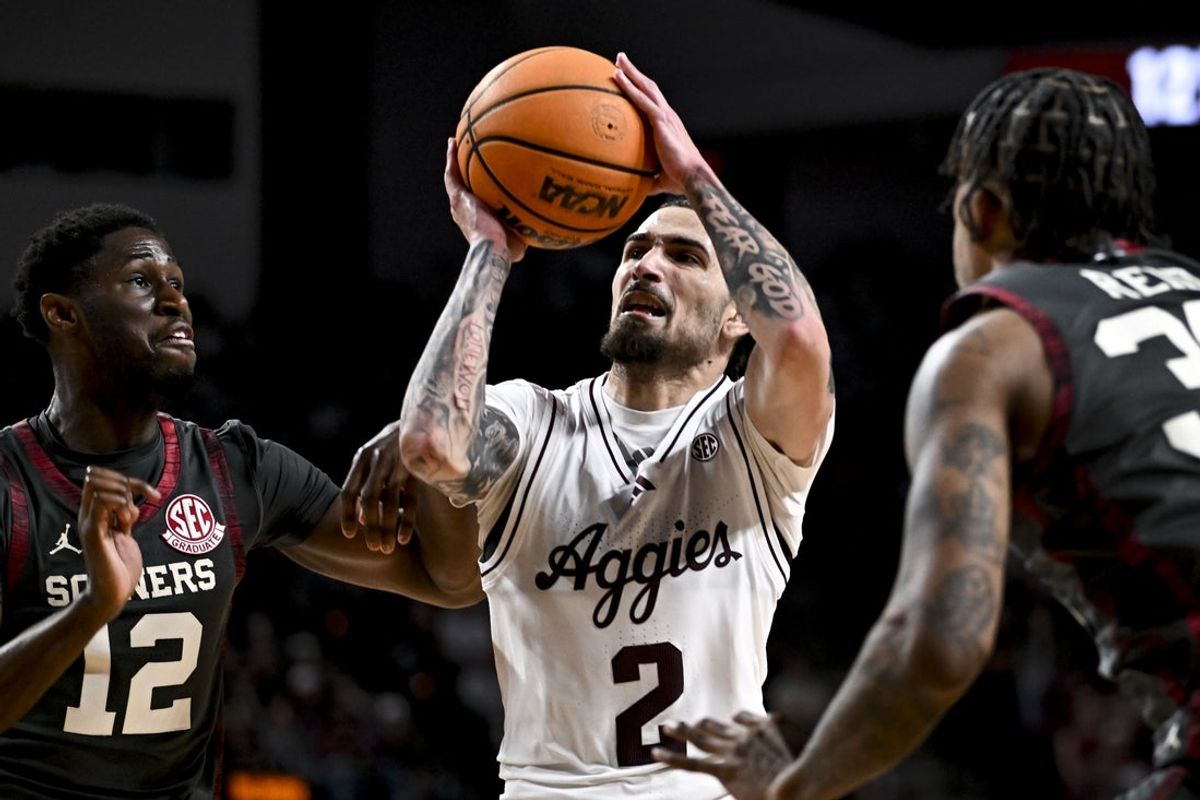 Jan 10, 2026; College Station, Texas, USA; Texas A&M Aggies guard Pop Isaacs (2) drives between Oklahoma Sooners guard Jadon Jones (12) and forward Derrion Reid (35) during the first half at Reed Arena. Mandatory Credit: Maria Lysaker-Imagn Images