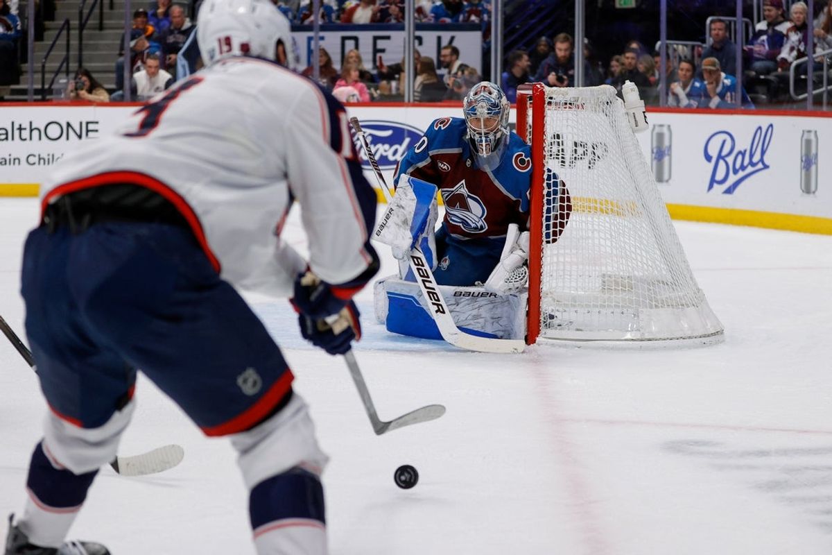 Jan 10, 2026; Denver, Colorado, USA; Colorado Avalanche goaltender Trent Miner (50) looks on as Columbus Blue Jackets center Adam Fantilli (19) controls the puck in the first period at Ball Arena. Mandatory Credit: Isaiah J. Downing-Imagn Images