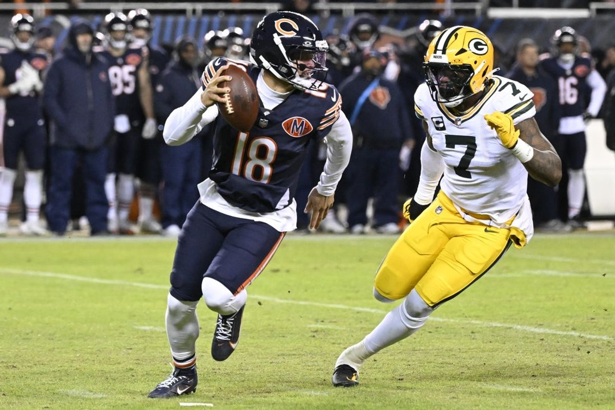 Jan 10, 2026; Chicago, IL, USA;  Chicago Bears quarterback Caleb Williams (18) rolls out as Green Bay Packers linebacker Quay Walker (7) applies the pressure during the first half of an NFC Wild Card Round game at Soldier Field. Mandatory Credit: Matt Marton-Imagn Images