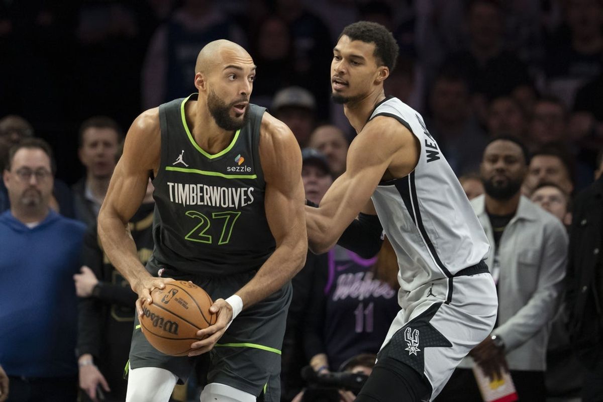 Jan 11, 2026; Minneapolis, Minnesota, USA; Minnesota Timberwolves center Rudy Gobert (27) holds the ball as San Antonio Spurs forward Victor Wembanyama (1) plays defense in the first half at Target Center. Mandatory Credit: Jesse Johnson-Imagn Images