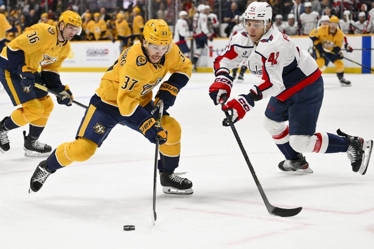 Jan 11, 2026; Nashville, Tennessee, USA;  Washington Capitals defenseman Martin Fehérváry (42) pokes the puck away from Nashville Predators defenseman Nick Blankenburg (37) during the first period at Bridgestone Arena. Mandatory Credit: Steve Roberts-Imagn Images
