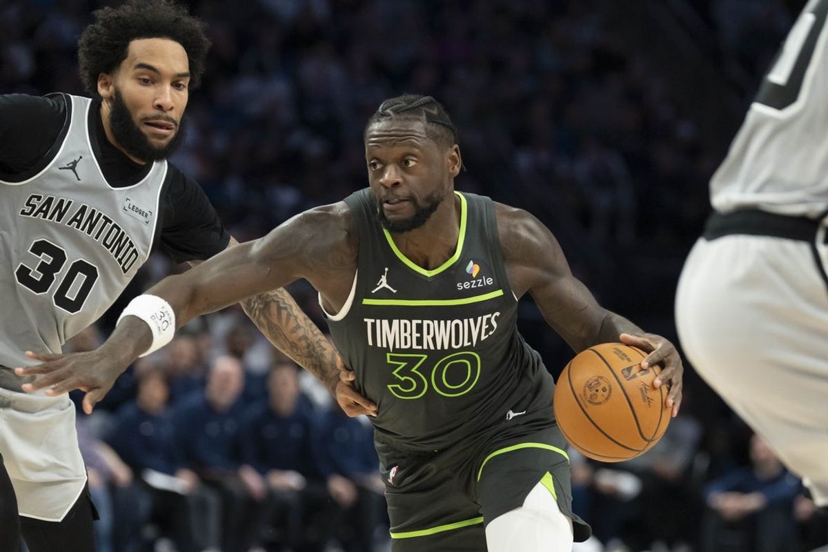 Jan 11, 2026; Minneapolis, Minnesota, USA; Minnesota Timberwolves forward Julius Randle (30) dribbles the ball past San Antonio Spurs forward Julian Champagnie (30) in the second half at Target Center. Mandatory Credit: Jesse Johnson-Imagn Images