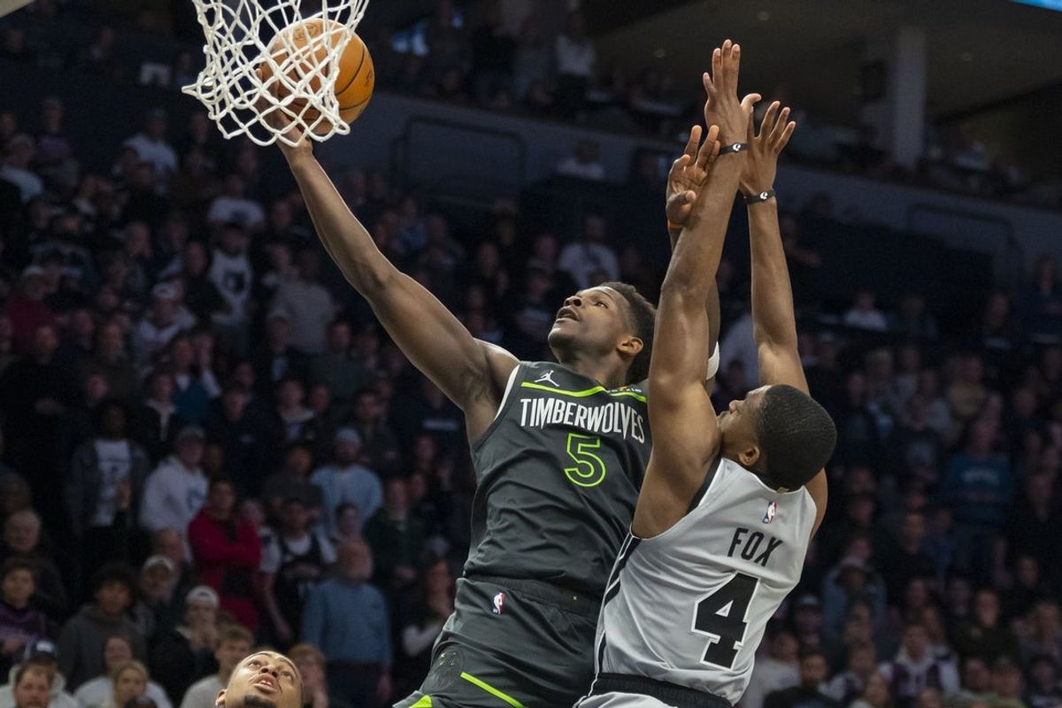 Jan 11, 2026; Minneapolis, Minnesota, USA; Minnesota Timberwolves guard Anthony Edwards (5) drives to the basket past San Antonio Spurs guard De'aaron Fox (4) in the second half at Target Center. Mandatory Credit: Jesse Johnson-Imagn Images