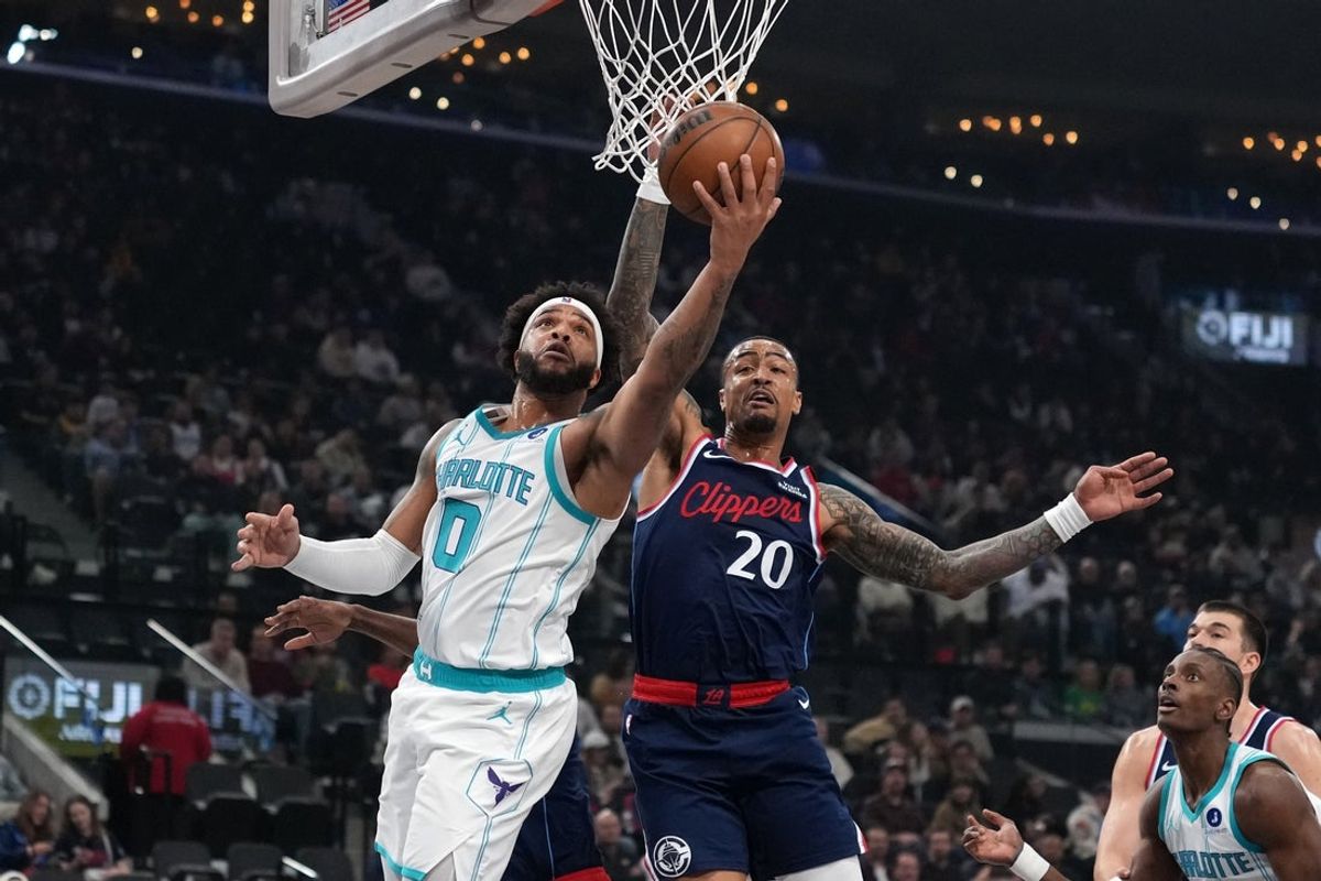 Jan 12, 2026; Inglewood, California, USA; Charlotte Hornets forward Miles Bridges (0) shoots the ball against LA Clippers forward John Collins (20) in the first half at Intuit Dome. Mandatory Credit: Kirby Lee-Imagn Images