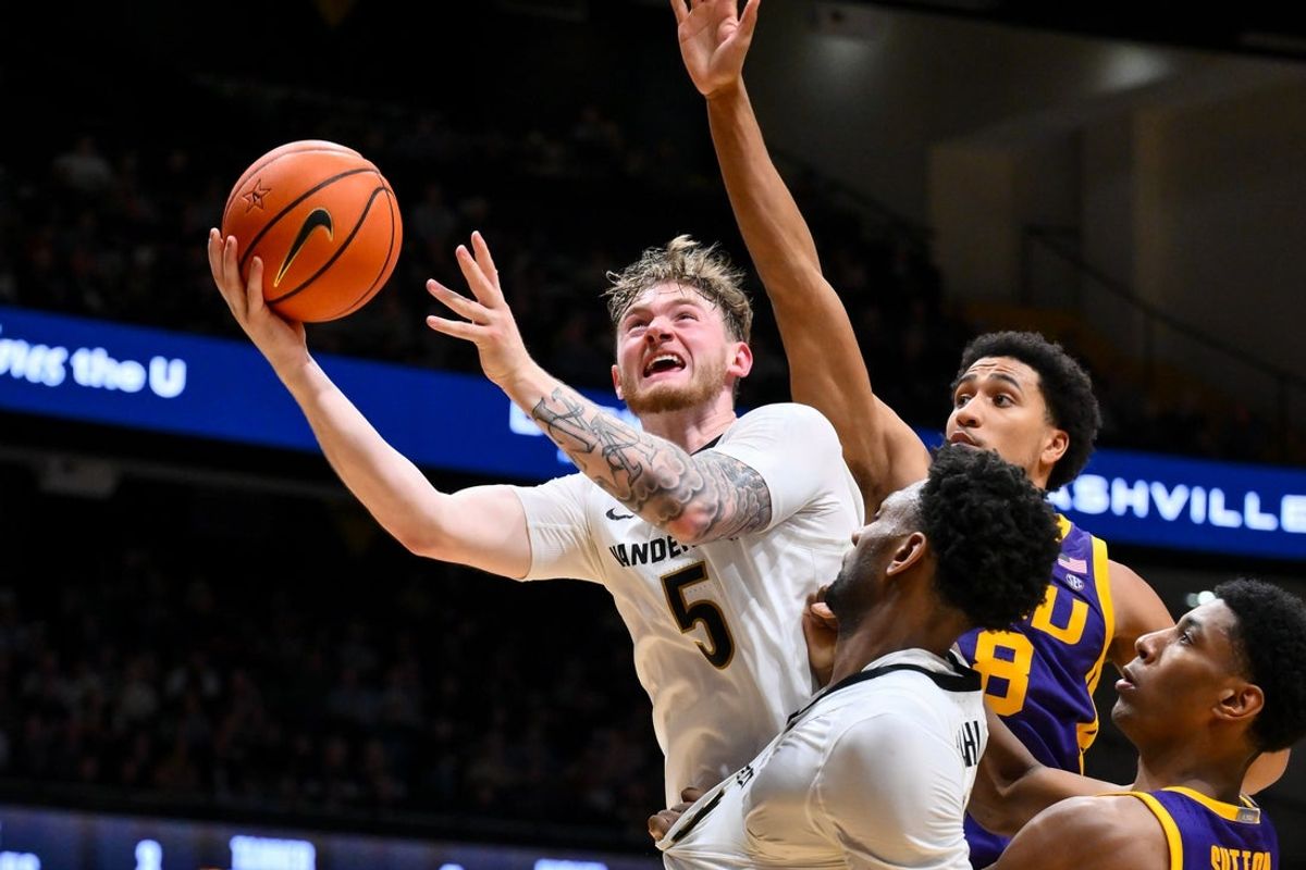 Jan 10, 2026; Nashville, Tennessee, USA;  Vanderbilt Commodores forward Tyler Nickel (5) lays the ball in over Louisiana State Tigers forward Pablo Tamba (8) during the second half at Memorial Gymnasium. Mandatory Credit: Steve Roberts-Imagn Images
