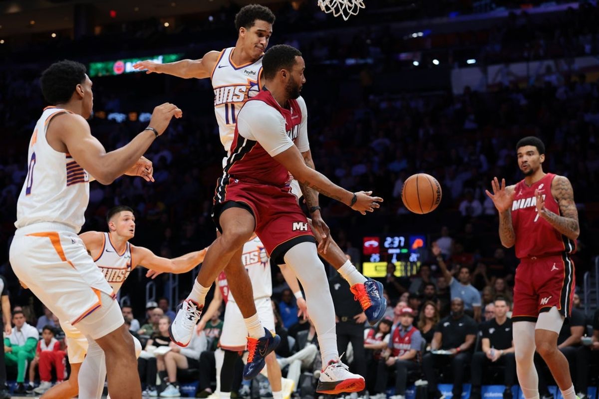 Jan 13, 2026; Miami, Florida, USA; Miami Heat guard Norman Powell (24) passes the ball to center Kel'el Ware (7) against the Phoenix Suns during the first quarter at Kaseya Center. Mandatory Credit: Sam Navarro-Imagn Images
