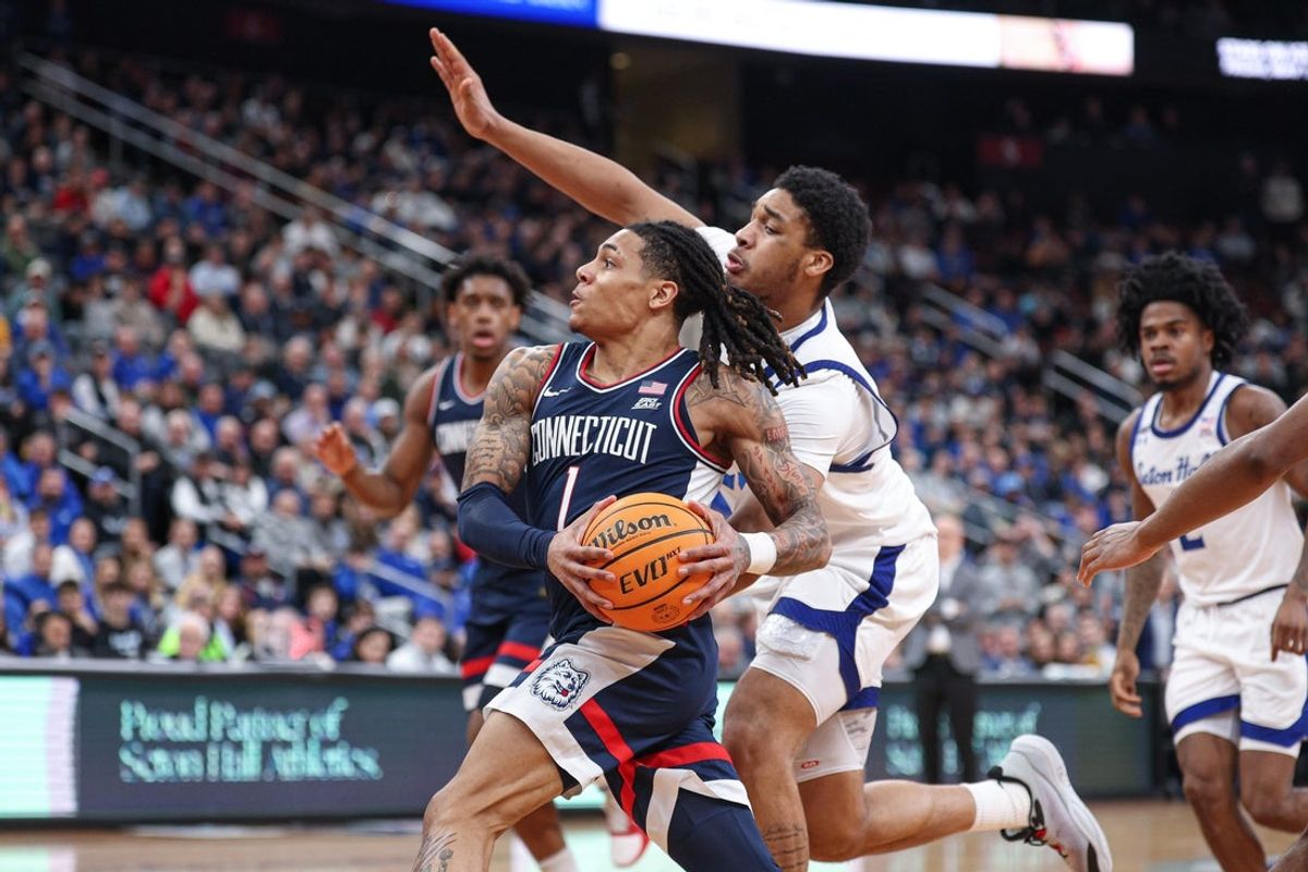 Jan 13, 2026; Newark, New Jersey, USA; UConn Huskies guard Solo Ball (1) goes to the basket as Seton Hall Pirates center Najai Hines (25) during the first half at Prudential Center. Mandatory Credit: Vincent Carchietta-Imagn Images