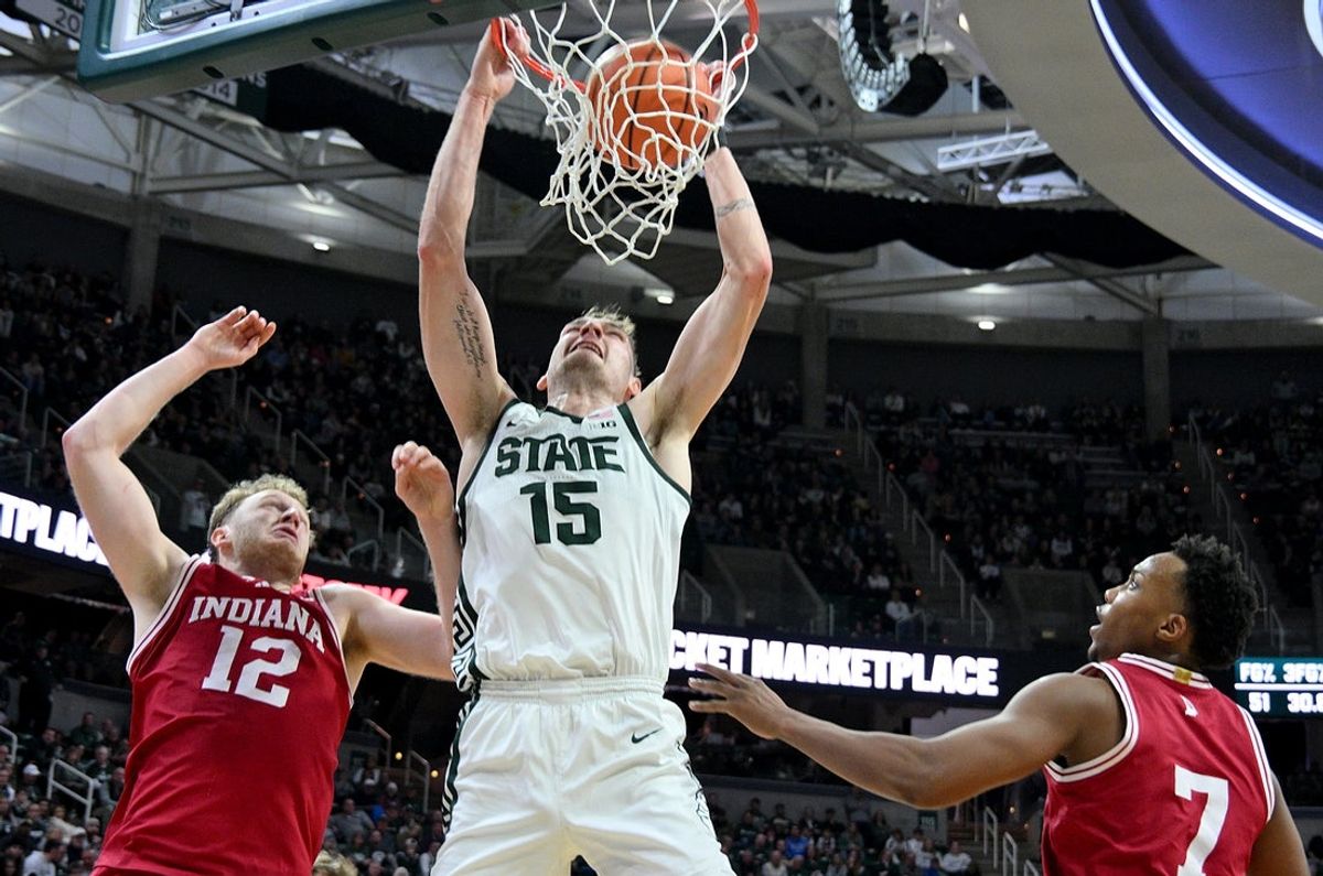 Jan 13, 2026; East Lansing, Michigan, USA;  Michigan State Spartans center Carson Cooper (15) dunks the ball over Indiana Hoosiers forward Tucker Devries (12) and  forward Nick Dorn (7) during the second half at Jack Breslin Student Events Center. Mandatory Credit: Dale Young-Imagn Images