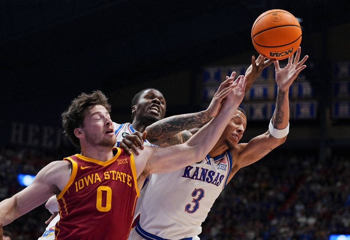 Jan 13, 2026; Lawrence, Kansas, USA; Iowa State Cyclones guard Nate Heise (0) fights for a rebound against Kansas Jayhawks guard Tre White (3) and forward Flory Bidunga (40) during the first half at Allen Fieldhouse. Mandatory Credit: Jay Biggerstaff-Imagn Images