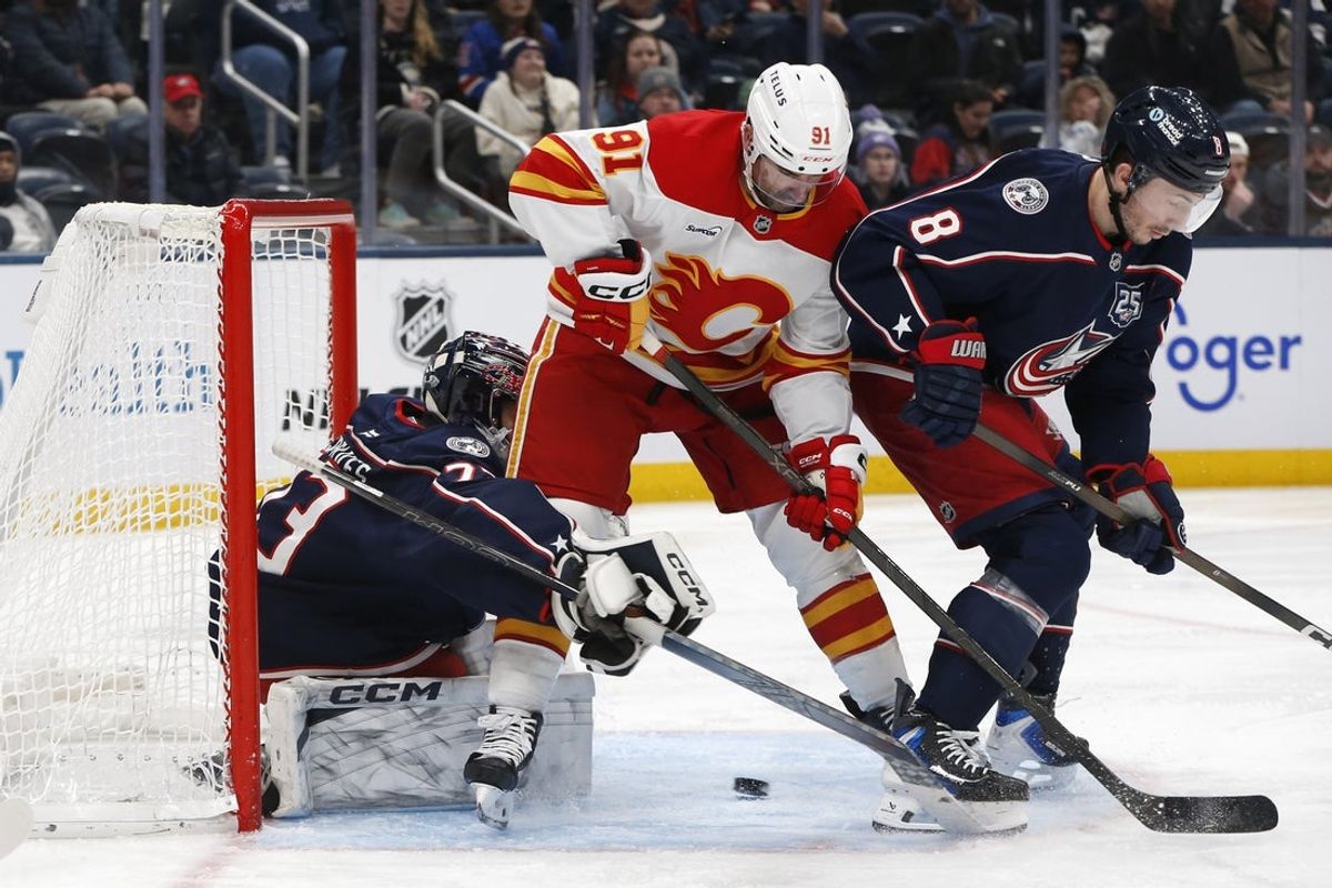 Jan 13, 2026; Columbus, Ohio, USA; Columbus Blue Jackets goalie Jet Greaves (73) makes a save though the screen of Calgary Flames center Nazem Kadri (91) during the third period at Nationwide Arena. Mandatory Credit: Russell LaBounty-Imagn Images