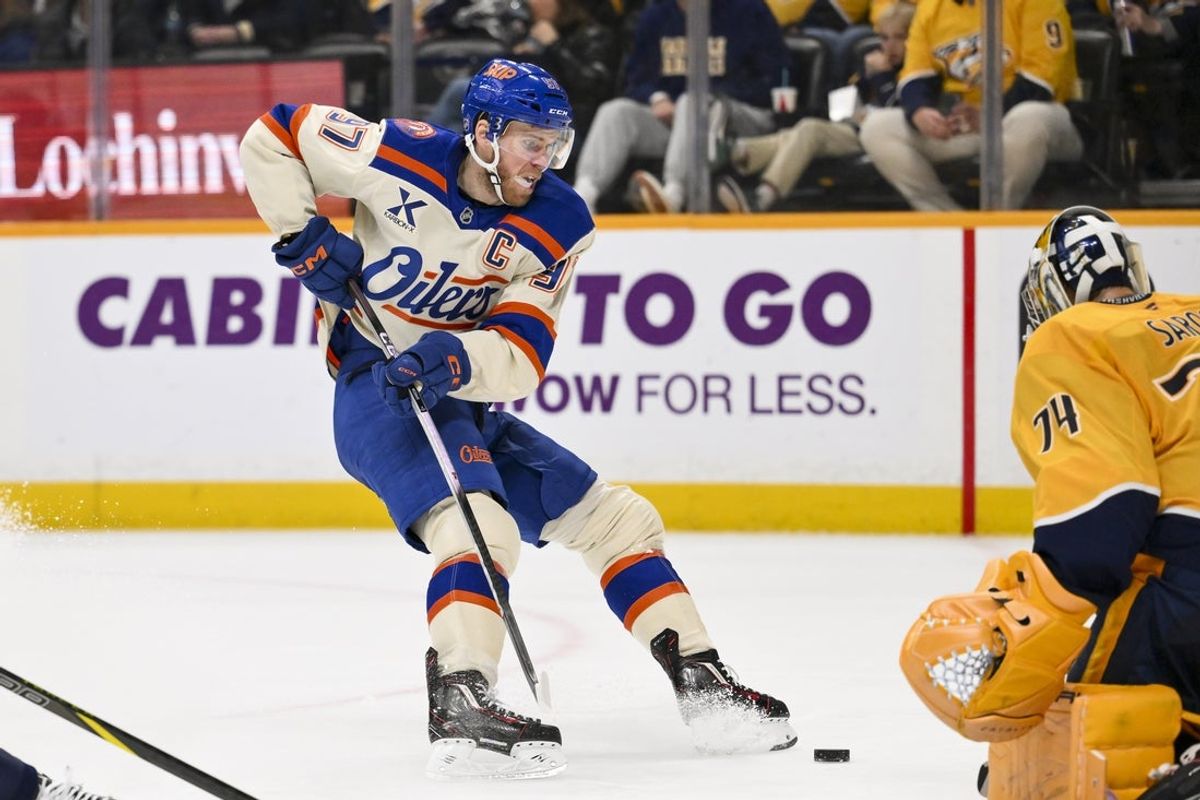 Jan 13, 2026; Nashville, Tennessee, USA;  Nashville Predators goaltender Juuse Saros (74) blocks the shot of Edmonton Oilers center Connor McDavid (97) during the second period at Bridgestone Arena. Mandatory Credit: Steve Roberts-Imagn Images