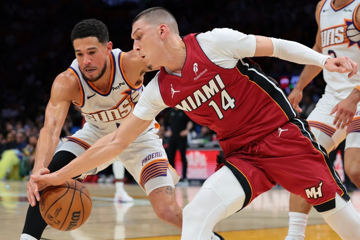 Jan 13, 2026; Miami, Florida, USA; Miami Heat guard Tyler Herro (14) and Phoenix Suns guard Devin Booker (1) battle for a loose ball during the second quarter at Kaseya Center. Mandatory Credit: Sam Navarro-Imagn Images
