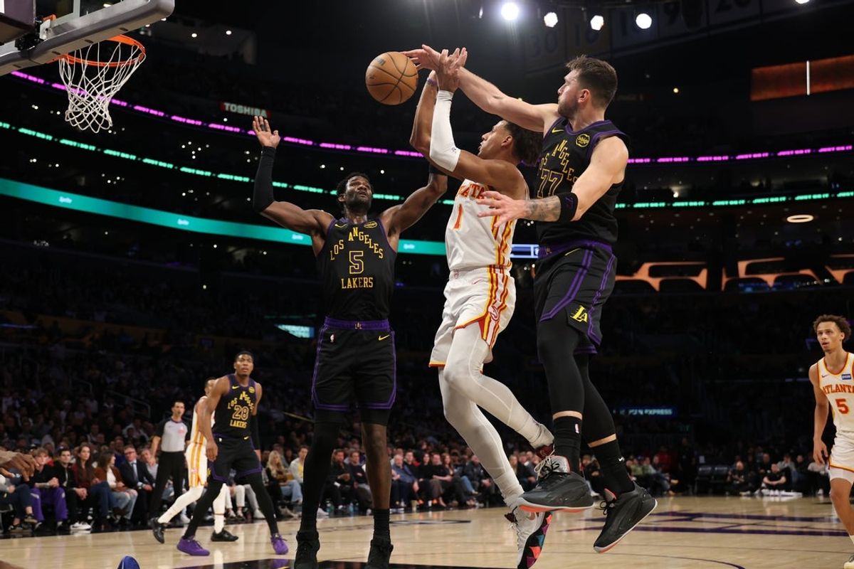 Jan 13, 2026; Los Angeles, California, USA;  Los Angeles Lakers guard Luka Doncic (77) blocks a shot by Atlanta Hawks forward Jalen Johnson (1) during the second quarter at Crypto.com Arena. Mandatory Credit: Kiyoshi Mio-Imagn Images
