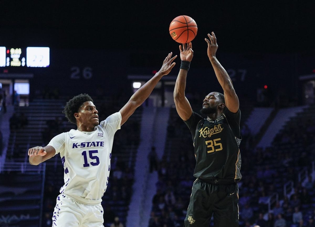 Jan 14, 2026; Manhattan, Kansas, USA; UCF Knights forward Devan Cambridge (35) shoots against Kansas State Wildcats forward Taj Manning (15) during the first half at Bramlage Coliseum. Mandatory Credit: Jay Biggerstaff-Imagn Images