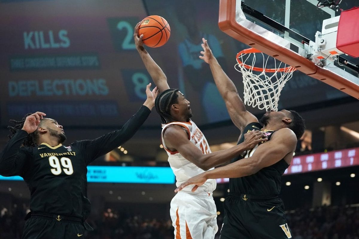 Jan 14, 2026; Austin, Texas, USA; Texas Longhorns guard Tramon Mark (12) dunks the ball against Vanderbilt Commodores forward Devin McGlockton (99) and forward AK Okereke (10) during the first half at Moody Center. Mandatory Credit: Dustin Safranek-Imagn Images