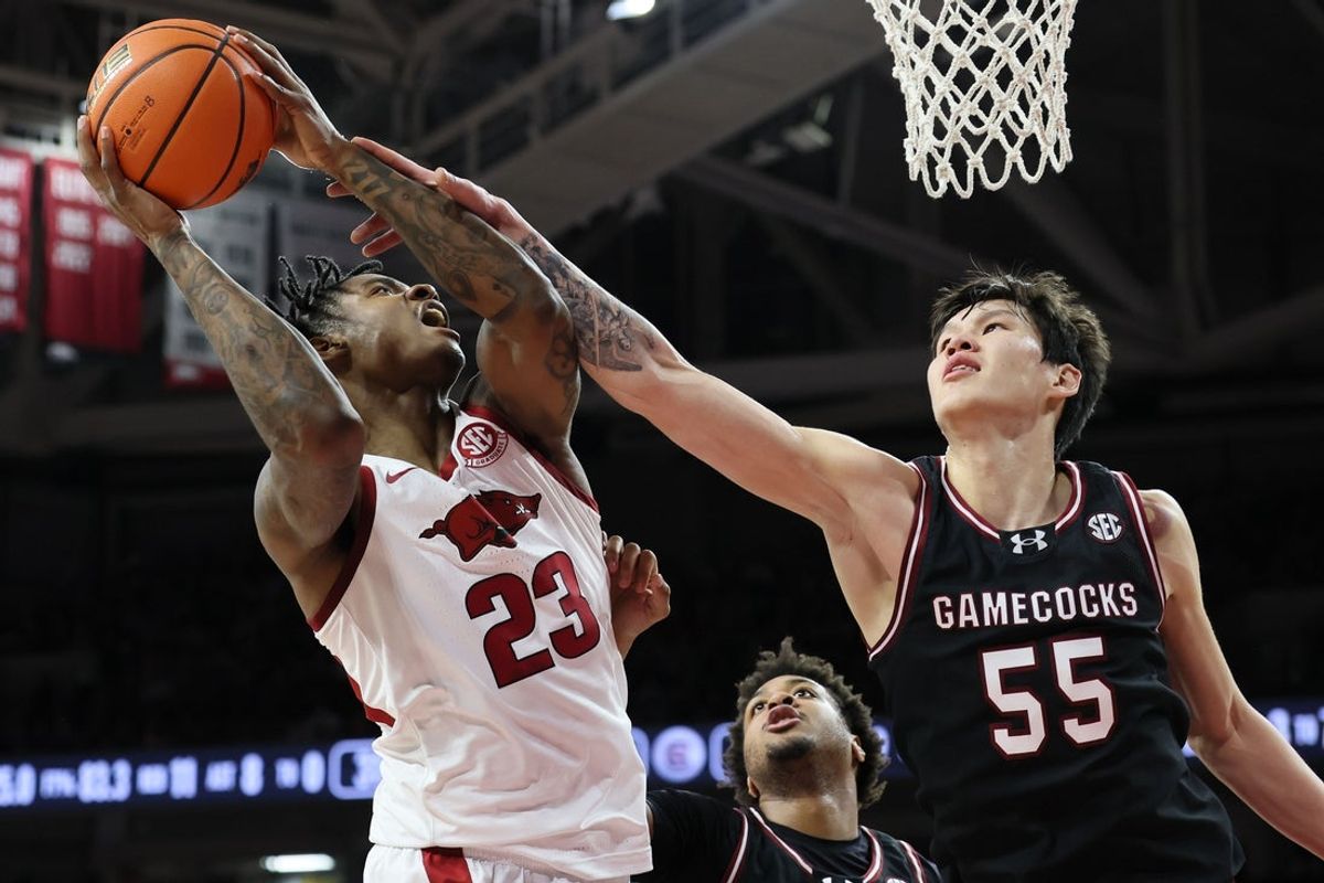 Jan 14, 2026; Fayetteville, Arkansas, USA; Arkansas Razorbacks forward Nick Pringle (23) is found during the first half by South Carolina Gamecocks guard Mike Sharavjamts (55) at Bud Walton Arena. Mandatory Credit: Nelson Chenault-Imagn Images
