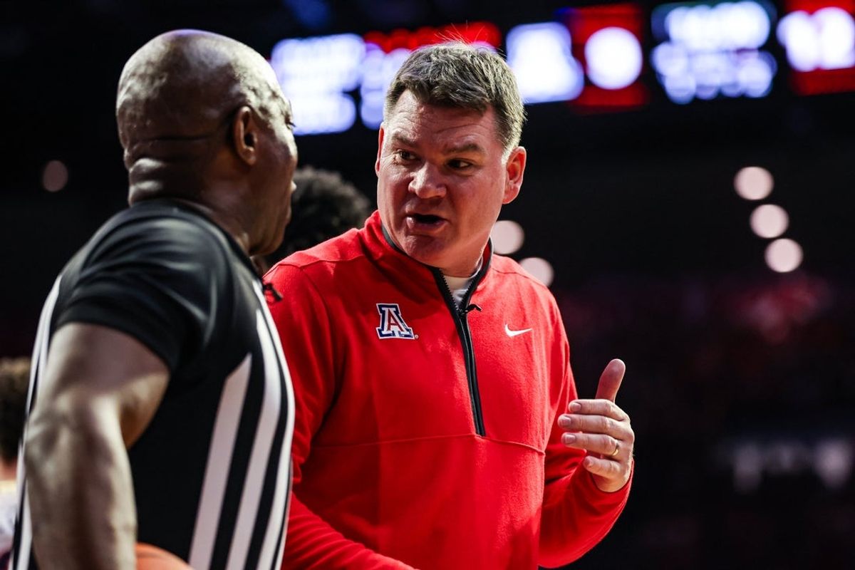 Jan 14, 2026; Tucson, Arizona, USA; Arizona Wildcats head coach Tommy Lloyd talks with the referee during the first half of the game against the Arizona State Sun Devils at McKale Memorial Center. Mandatory Credit: Aryanna Frank-Imagn Images