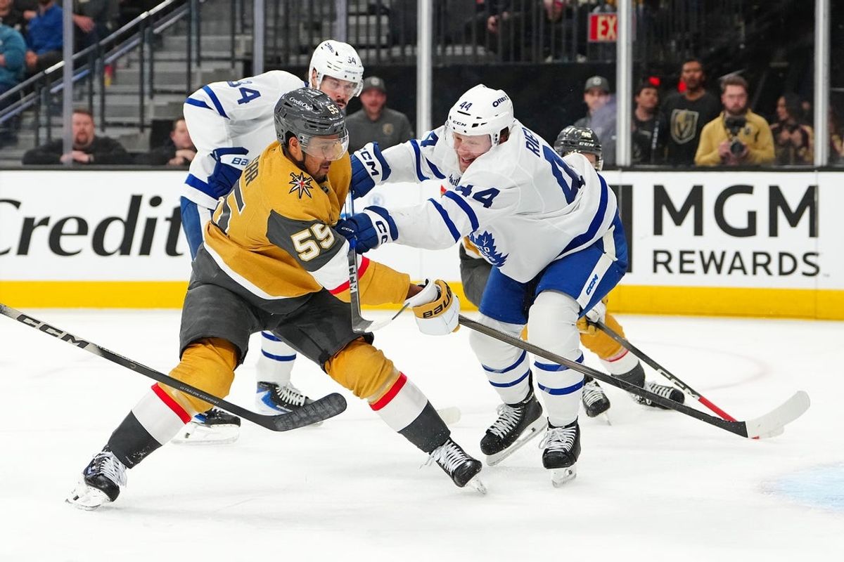 Jan 15, 2026; Las Vegas, Nevada, USA; Vegas Golden Knights right wing Keegan Kolesar (55) scores on a shot as Toronto Maple Leafs defenseman Morgan Rielly (44) applies a check during the second period at T-Mobile Arena. Mandatory Credit: Stephen R. Sylvanie-Imagn Images