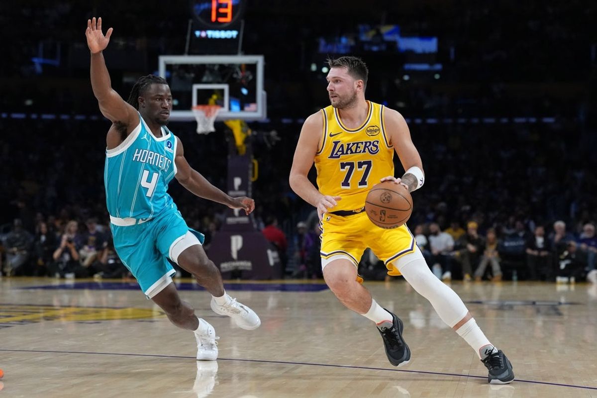 Jan 15, 2026; Los Angeles, California, USA; Los Angeles Lakers guard Luka Doncic (77) dribbles the ball against Charlotte Hornets guard Sion James (4) in the first half at Crypto.com Arena. Mandatory Credit: Kirby Lee-Imagn Images