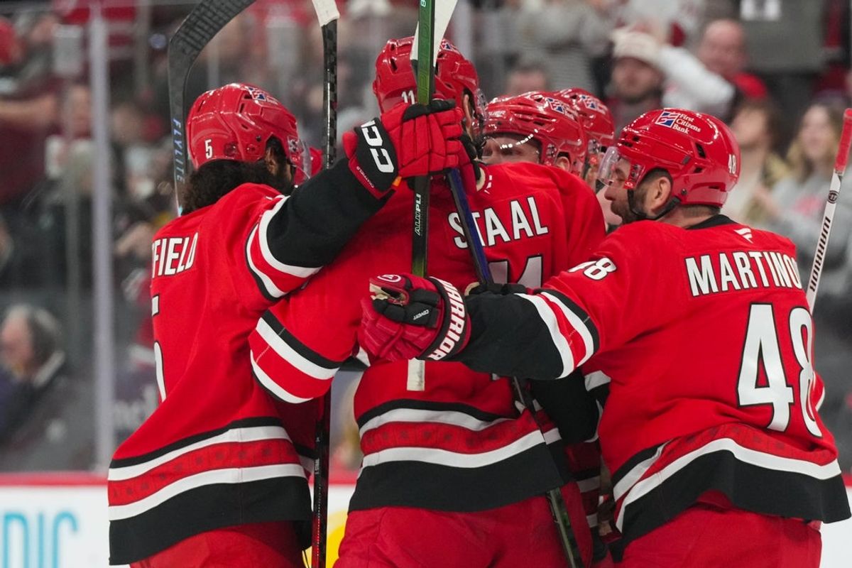 Jan 16, 2026; Raleigh, North Carolina, USA;  Carolina Hurricanes left wing Nikolaj Ehlers (27) is congratulated by center Jordan Staal (11), left wing Jordan Martinook (48), defenseman Jalen Chatfield (5) and defenseman Jaccob Slavin (74) after his goal against the Florida Panthers during the first period at Lenovo Center. Mandatory Credit: James Guillory-Imagn Images