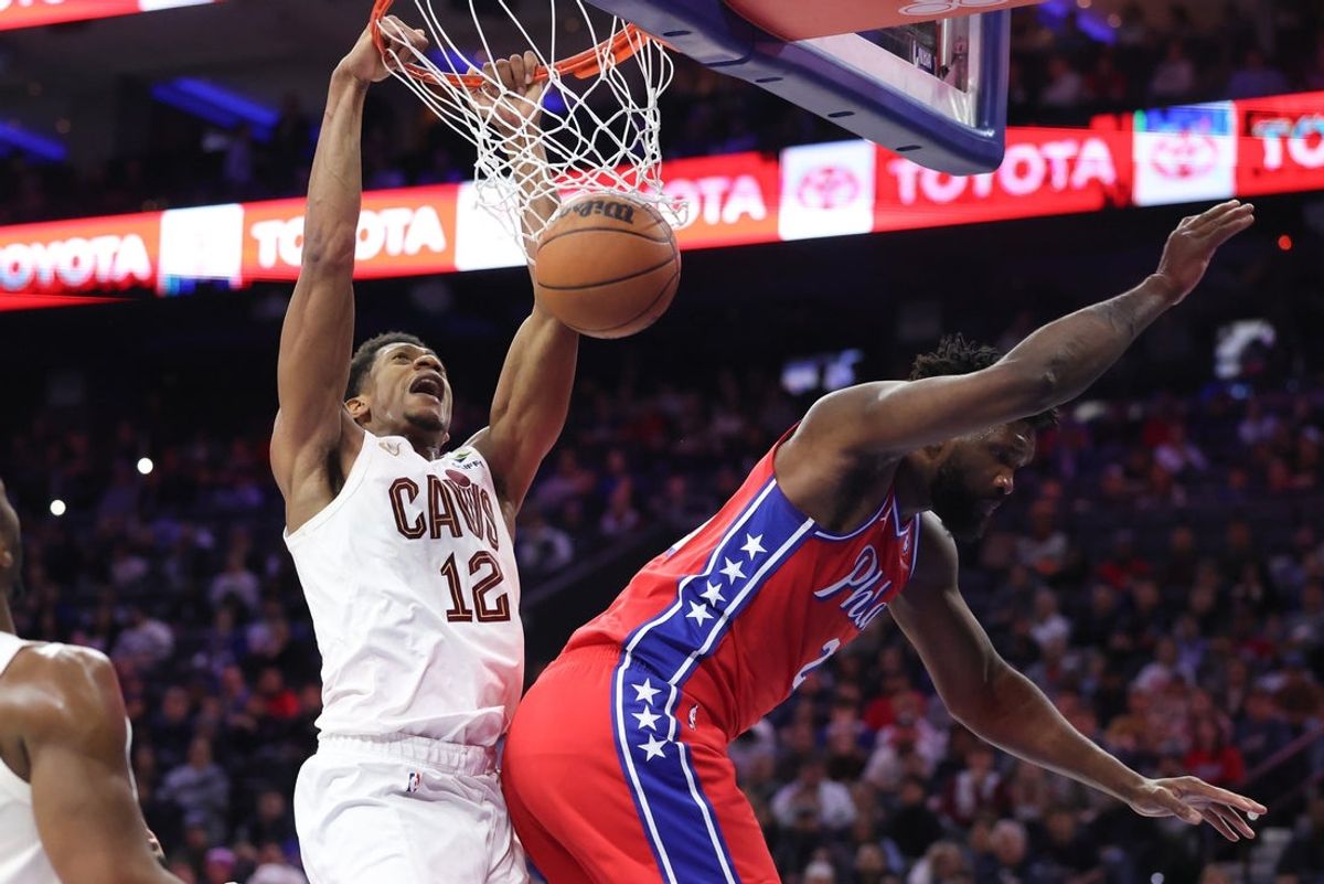 Jan 16, 2026; Philadelphia, Pennsylvania, USA; Cleveland Cavaliers forward De'andre Hunter (12) dunks the ball past Philadelphia 76ers center Joel Embiid (21) during the fourth quarter at Xfinity Mobile Arena. Mandatory Credit: Bill Streicher-Imagn Images