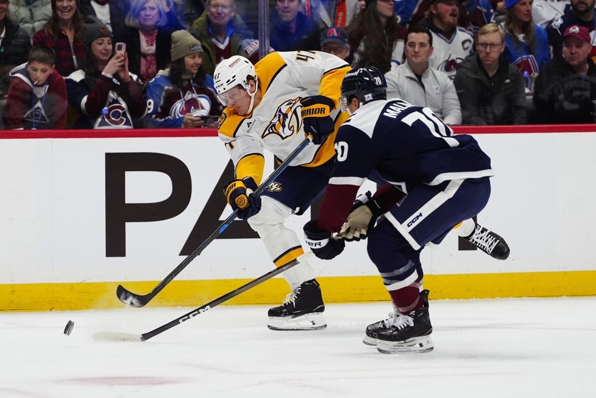 Jan 16, 2026; Denver, Colorado, USA; Colorado Avalanche defenseman Sam Malinski (70) defends the shot on goal by Nashville Predators right wing Michael McCarron (47) in the first period at Ball Arena. Mandatory Credit: Ron Chenoy-Imagn Images