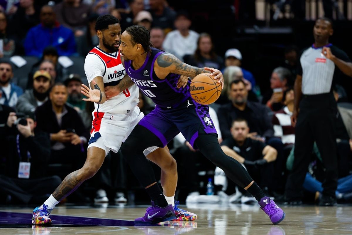 Jan 16, 2026; Sacramento, California, USA; Sacramento Kings guard DeMar DeRozan (10) drives against Washington Wizards guard Malaki Branham (8) during the second quarter at Golden 1 Center. Mandatory Credit: Sergio Estrada-Imagn Images