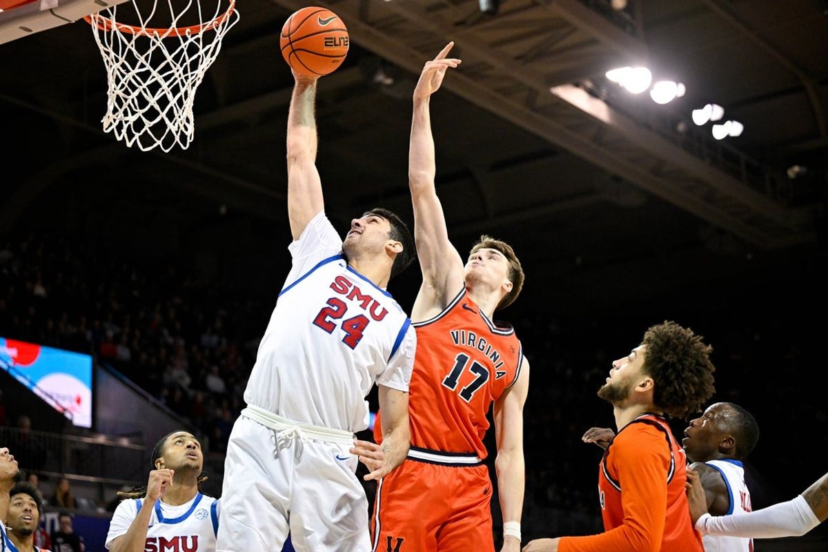 Jan 17, 2026; Dallas, Texas, USA; SMU Mustangs center Samet Yigitoglu (24) and Virginia Cavaliers center Johann Grunloh (17) battle for the rebound during the first half at Moody Coliseum. Mandatory Credit: Jerome Miron-Imagn Images