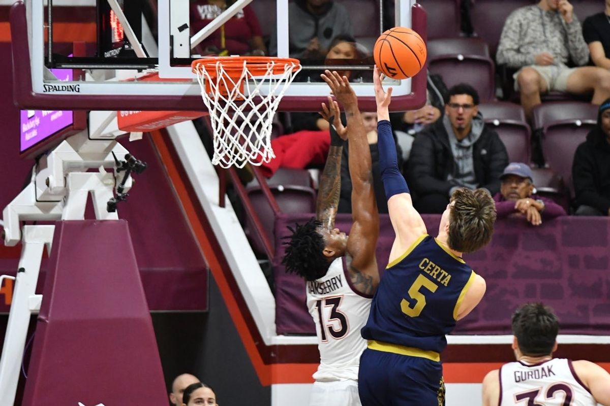 Jan 17, 2026; Blacksburg, Virginia, USA;  Notre Dame Fighting Irish guard Cole Certa (5) lays the ball up as Virginia Tech Hokies forward Amani Hansberry (13) defends during the first half at Cassell Coliseum. Mandatory Credit: Brian Bishop-Imagn Images