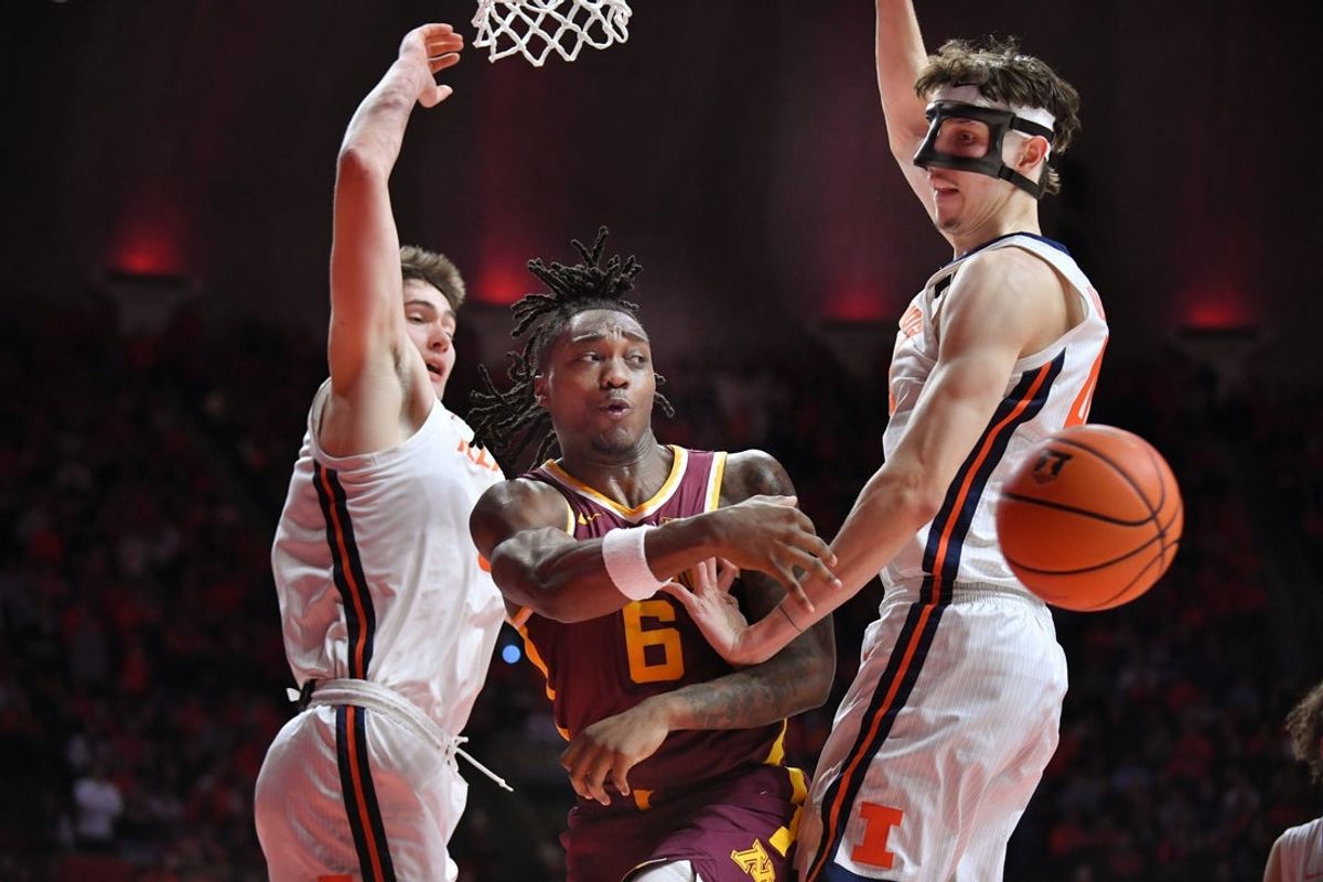 Jan 17, 2026; Champaign, Illinois, USA; Minnesota Golden Gophers guard Langston Reynolds (6) passes the ball between Illinois Fighting Illini forward David Mirkovic (0) and Zvonimir Ivisic (44) during the second half at State Farm Center. Mandatory Credit: Ron Johnson-Imagn Images