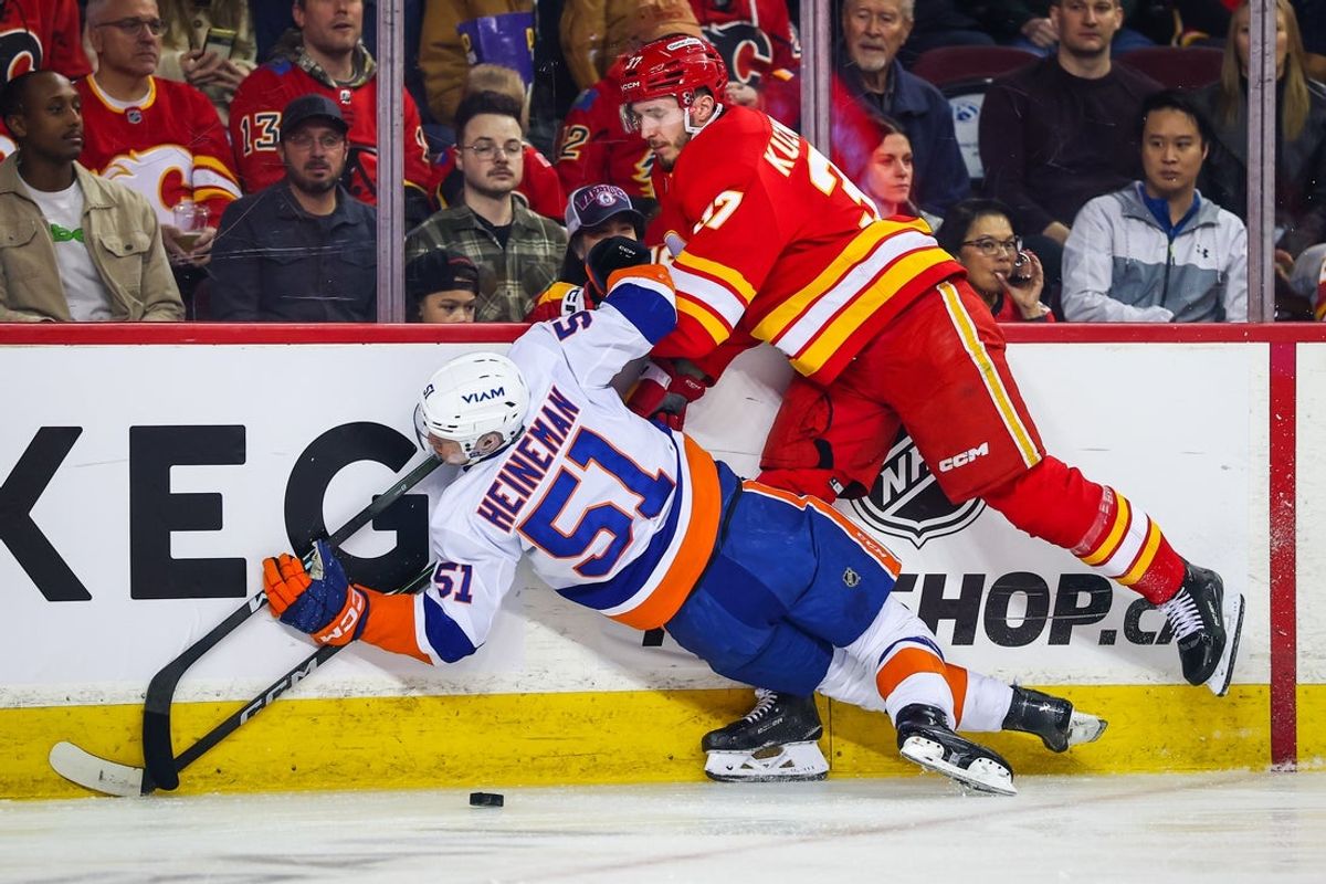 Jan 17, 2026; Calgary, Alberta, CAN; New York Islanders left wing Emil Heineman (51) and Calgary Flames defenseman Yan Kuznetsov (37) collide during the first period at Scotiabank Saddledome. Mandatory Credit: Sergei Belski-Imagn Images