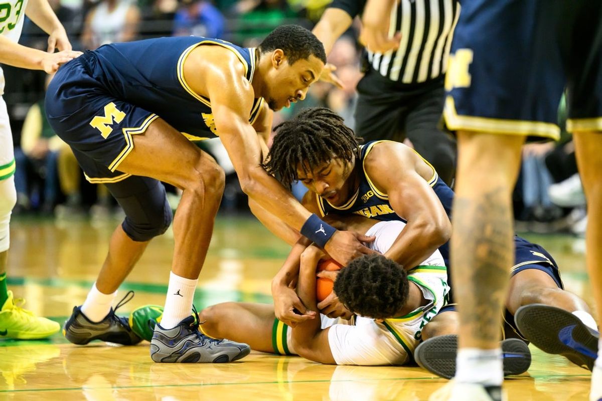 Jan 17, 2026; Eugene, Oregon, USA;  Michigan Wolverines forward Morez Johnson Jr. (21) battles Oregon Ducks guard Takai Simpkins (5) for a loose ball during the first half at Matthew Knight Arena. Mandatory Credit: Craig Strobeck-Imagn Images