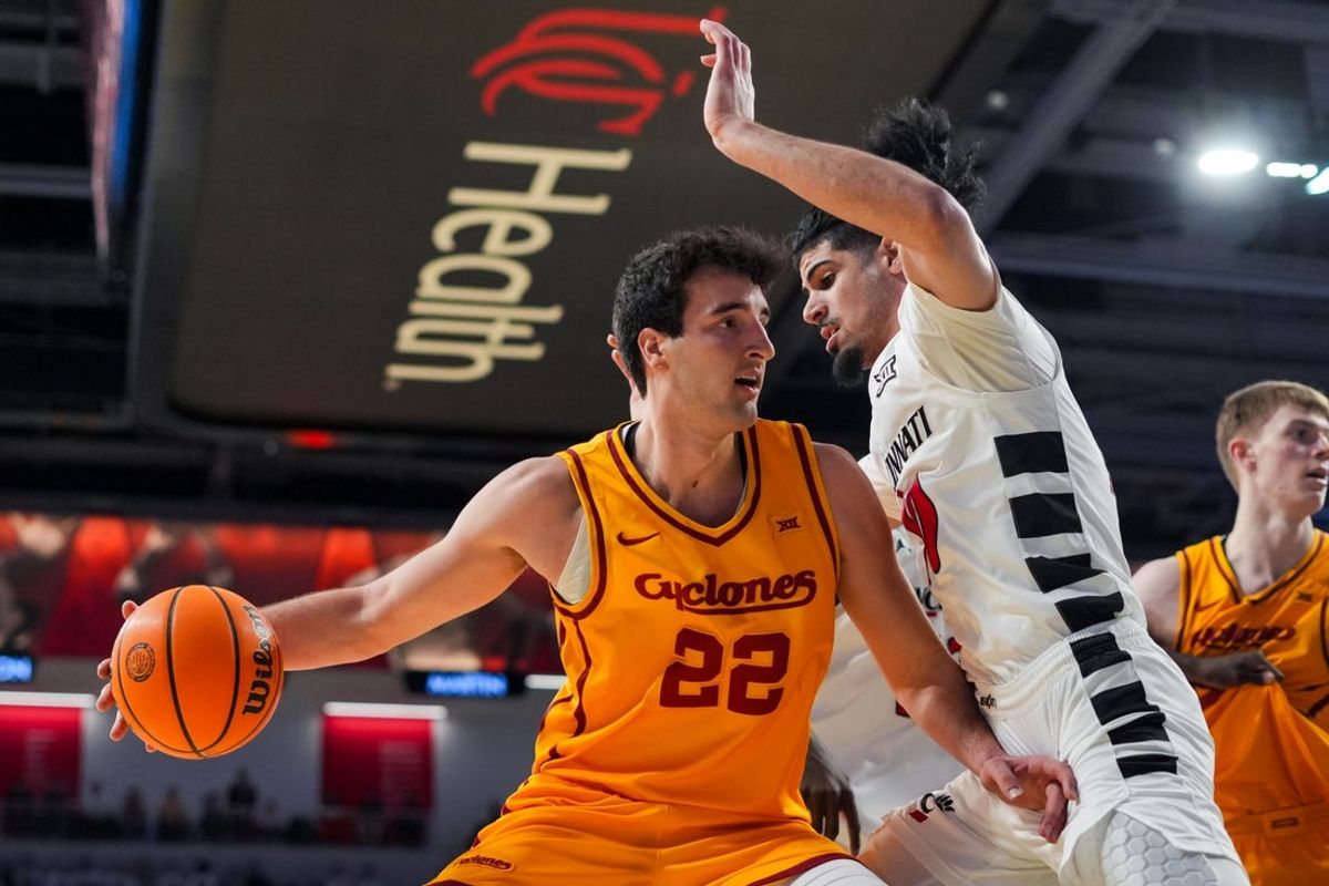 Jan 17, 2026; Cincinnati, Ohio, USA;  Iowa State Cyclones forward Milan Momcilovic (22) dribbles the ball against Cincinnati Bearcats guard Shon Abaev (10) in the first half at Fifth Third Arena. Mandatory Credit: Aaron Doster-Imagn Images