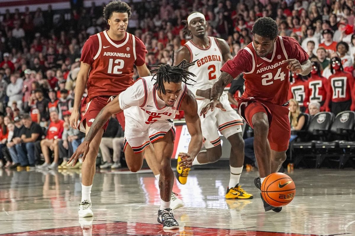 Jan 17, 2026; Athens, Georgia, USA; Georgia Bulldogs guard Jeremiah Wilkinson (5) and Arkansas Razorbacks forward Billy Richmond III (24) chase the ball during the first half at Stegeman Coliseum. Mandatory Credit: Dale Zanine-Imagn Images