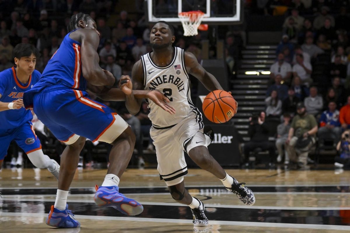 Jan 17, 2026; Nashville, Tennessee, USA;  Vanderbilt Commodores guard Duke Miles (2) drives to the basket past Florida Gators center Rueben Chinyelu (9) during the second half at Memorial Gymnasium. Mandatory Credit: Steve Roberts-Imagn Images