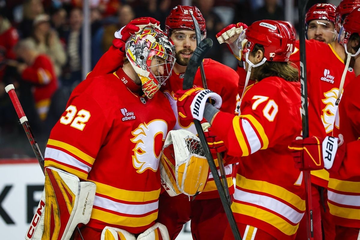 Jan 17, 2026; Calgary, Alberta, CAN; Calgary Flames goaltender Dustin Wolf (32) celebrates win with teammates after defeating New York Islanders at Scotiabank Saddledome. Mandatory Credit: Sergei Belski-Imagn Images