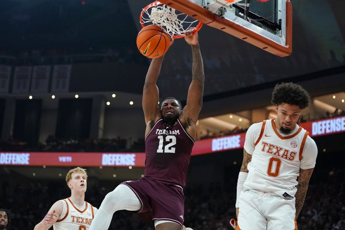 Jan 17, 2026; Austin, Texas, USA; Texas A&M Aggies forward Rashaun Agee (12) dunks against Texas Longhorns guard Jordan Pope (0) during the first half at Moody Center. Mandatory Credit: Dustin Safranek-Imagn Images