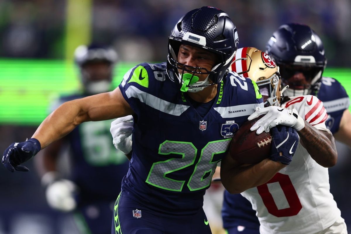 Jan 17, 2026; Seattle, WA, USA; Seattle Seahawks running back Zach Charbonnet (26) carries the ball as San Francisco 49ers cornerback Renardo Green (0) defends during the first half in an NFC Divisional Round game at Lumen Field. Mandatory Credit: Kevin Ng-Imagn Images