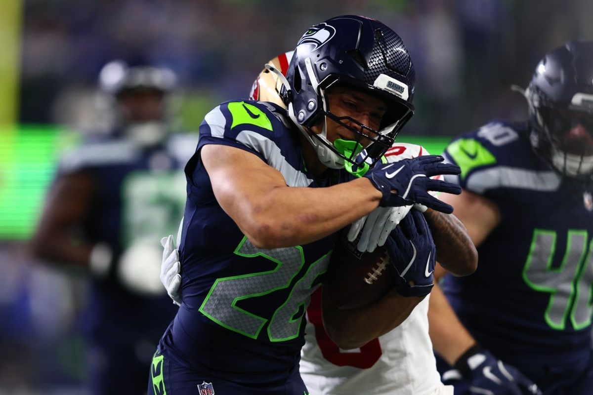 Jan 17, 2026; Seattle, WA, USA; Seattle Seahawks running back Zach Charbonnet (26) carries the ball as San Francisco 49ers cornerback Renardo Green (0) defends during the first half in an NFC Divisional Round game at Lumen Field. Mandatory Credit: Kevin Ng-Imagn Images