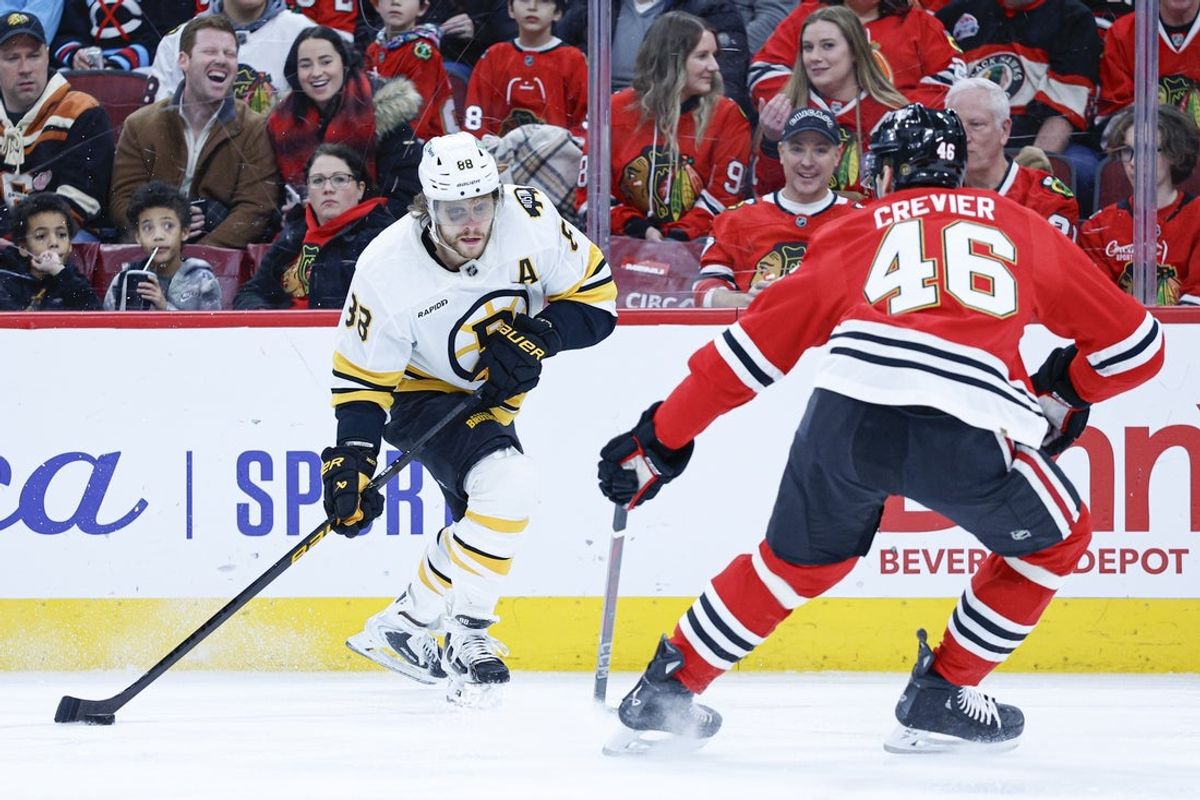 Jan 17, 2026; Chicago, Illinois, USA; Boston Bruins right wing David Pastrnak (88) looks to shoot against Chicago Blackhawks defenseman Louis Crevier (46) during the first period at United Center. Mandatory Credit: Kamil Krzaczynski-Imagn Images