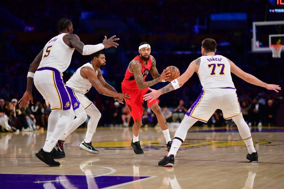 Jan 18, 2026; Los Angeles, California, USA; Toronto Raptors forward Brandon Ingram (3) moves the ball against Los Angeles Lakers center Deandre Ayton (5) guard Marcus Smart (36) and guard Luka Doncic (77) during the second half at Crypto.com Arena. Mandatory Credit: Gary A. Vasquez-Imagn Images