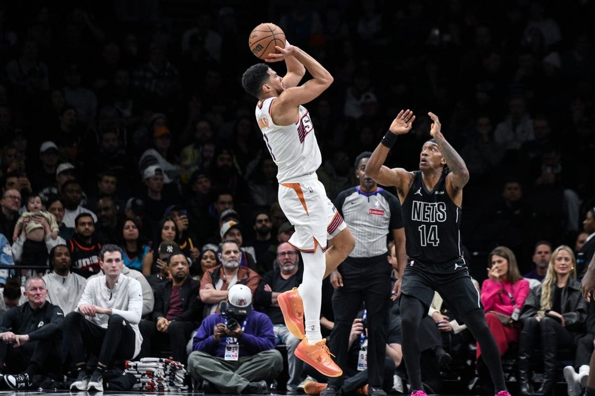 Jan 19, 2026; Brooklyn, New York, USA; Phoenix Suns guard Devin Booker (1) shoots the ball against Brooklyn Nets guard/forward Terance Mann (14) during the first half at Barclays Center. Mandatory Credit: John Jones-Imagn Images