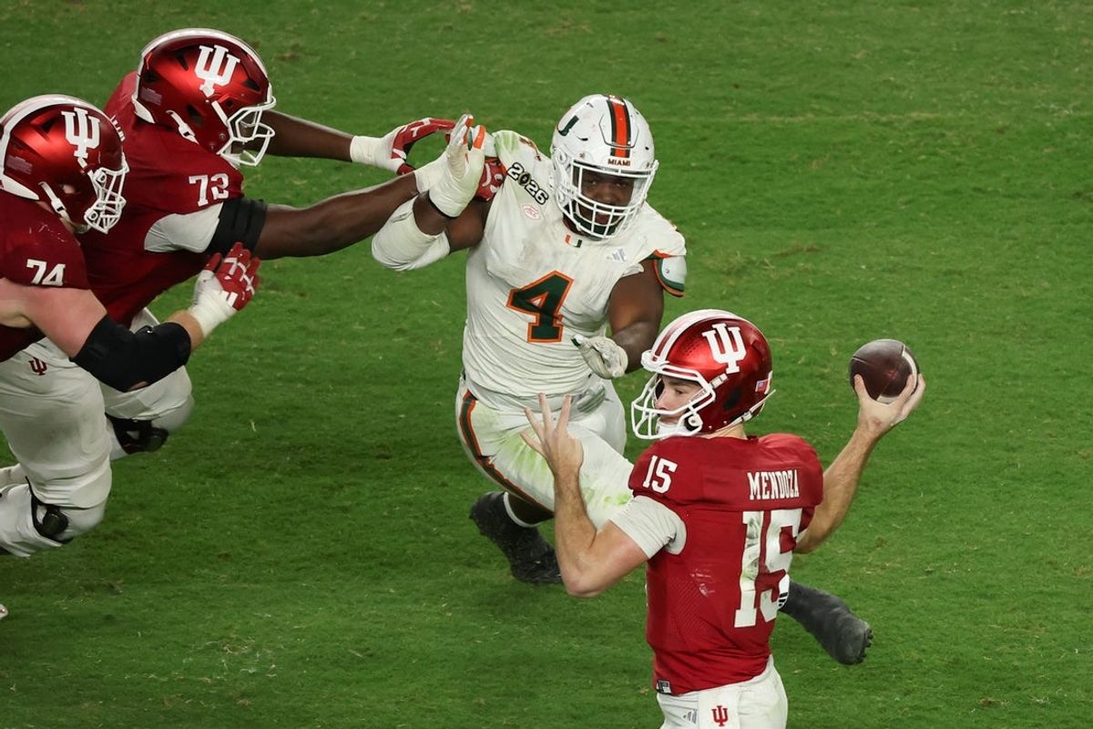 Indiana Hoosiers quarterback Fernando Mendoza (15) passes the ball under pressure by Miami Hurricanes defensive lineman Rueben Bain Jr. (4) in the third quarter during the College Football Playoff National Championship game at Hard Rock Stadium. Mandatory Credit: Kim Klement Neitzel-Imagn Images