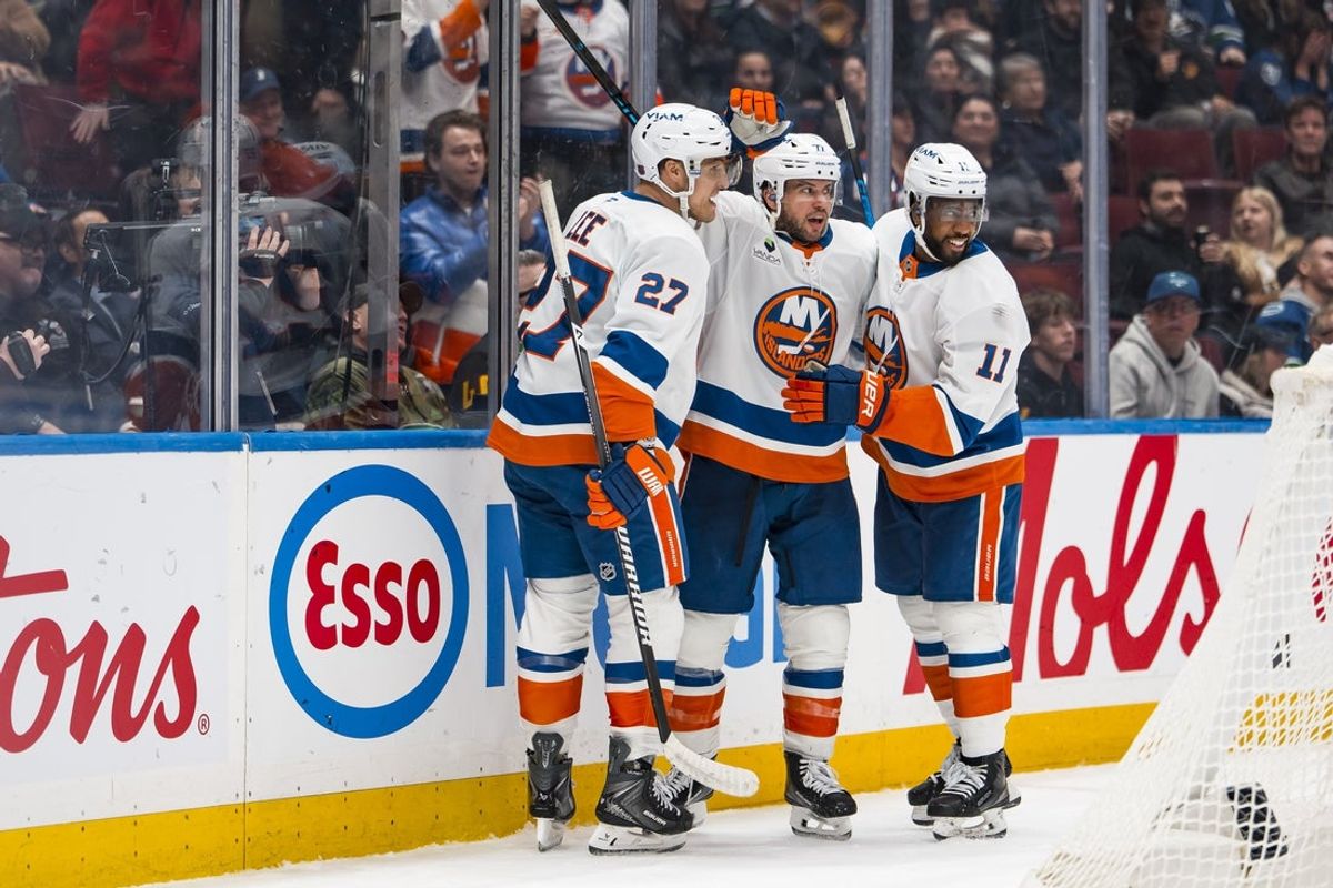 Jan 19, 2026; Vancouver, British Columbia, CAN; New York Islanders defenseman Tony DeAngelo (77) celebrates with forwards Anthony Duclair (11) and Anders Lee (27) after scoring a goal against the Vancouver Canucks in the third period at Rogers Arena. Mandatory Credit: Bob Frid-Imagn Images