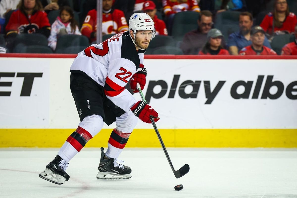 Jan 19, 2026; Calgary, Alberta, CAN; New Jersey Devils defenseman Brett Pesce (22) controls the puck against the Calgary Flames during the second period at Scotiabank Saddledome. Mandatory Credit: Sergei Belski-Imagn Images
