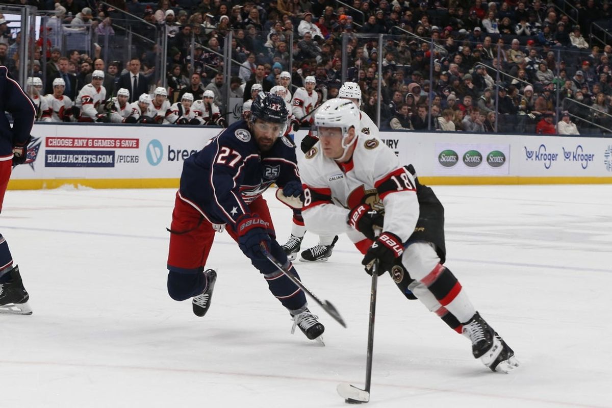 Jan 20, 2026; Columbus, Ohio, USA; Ottawa Senators left wing Tim Stutzle (18) skates the puck around Columbus Blue Jackets center Zach Aston-Reese (27) during the first period at Nationwide Arena. Mandatory Credit: Russell LaBounty-Imagn Images
